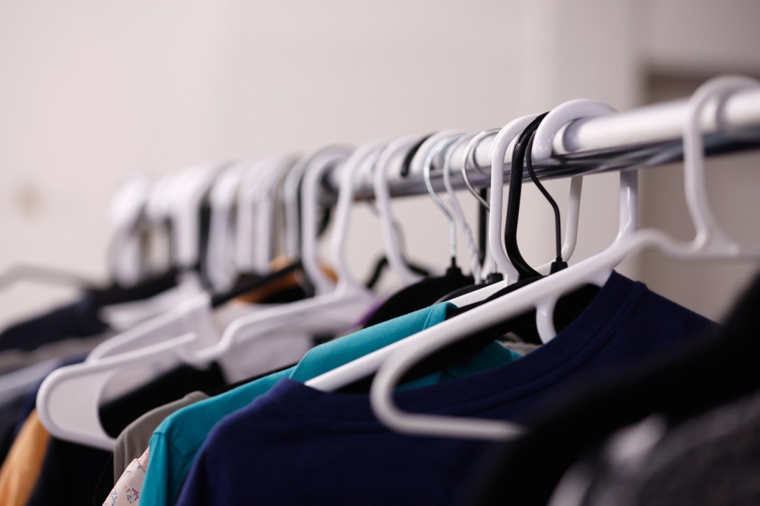 Clothes hanging from clothes hangers on a rack.