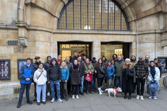 A group of people posing for a photo outside of a building.