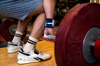 A person deadlifting weights at a gym.