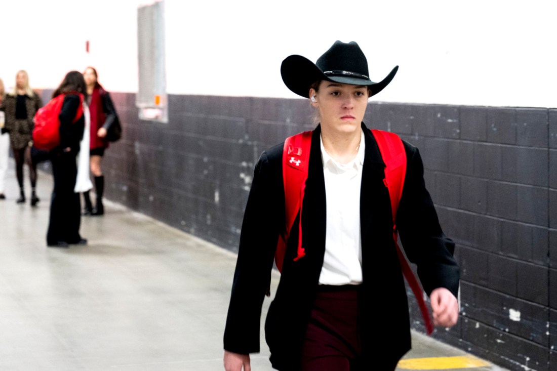 A women's hockey player walking into to TD Garden wearing a black cowboy hat.