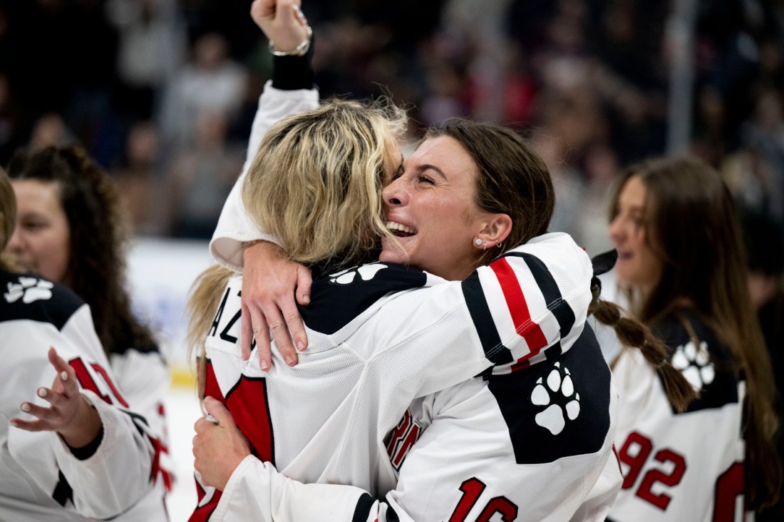 Women's hockey teammates hugging