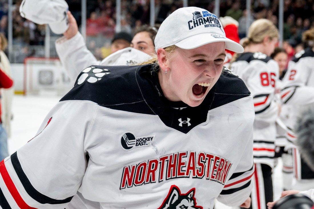 Women's hockey players cheering, wearing Beanpot Champion hats