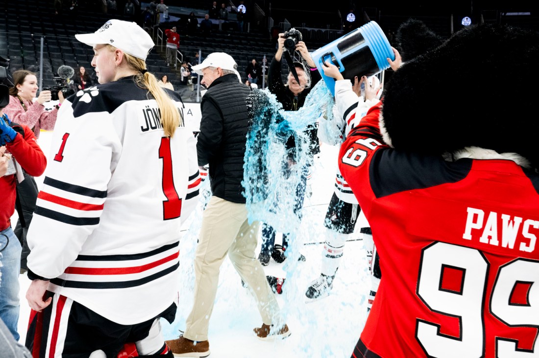 Women's hockey players dump sports drink on the coach.