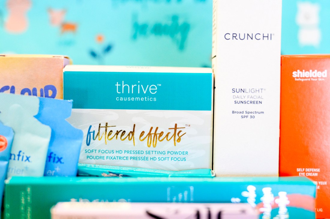 A lineup of beauty products, including Thrive Causemetics Filtered Effects pressed powder and Crunchi daily facial sunscreen.