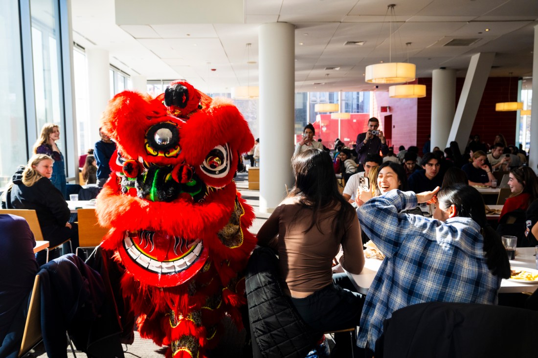 A vibrant red lion head from the Lunar New Year celebration captures attention as it moves through the dining hall at Northeastern.