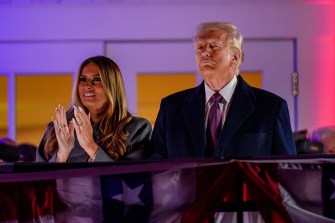 Melania and Donald Trump standing next to each other, Melania clapping her hands together.