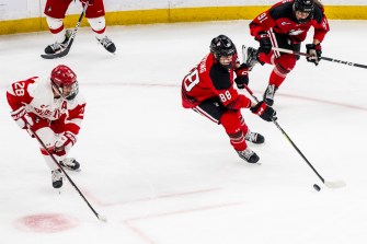 Two hockey players skating on the rink.