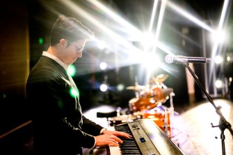 James Gutierrrez playing a piano in front of a microphone.