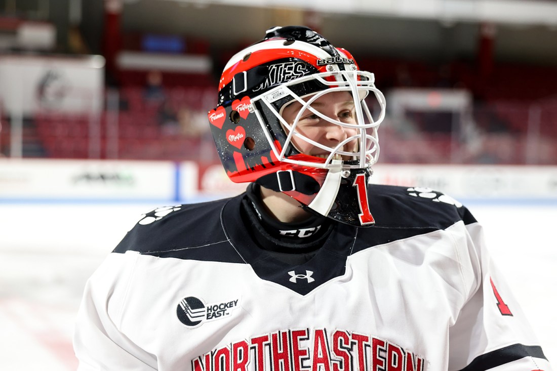 Lisa Jonsson in her hockey gear smiling.