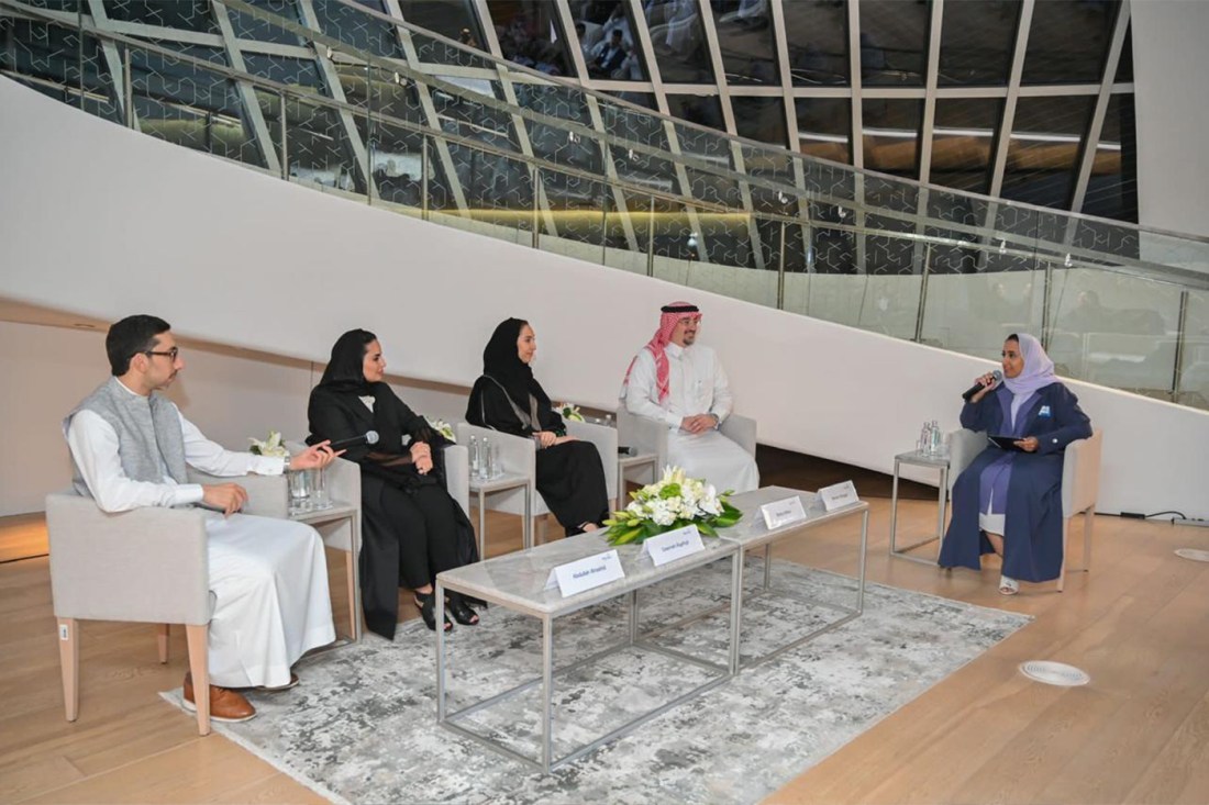 Deema Alayedh speaking to a panel of four other people in Saudi Arabia.