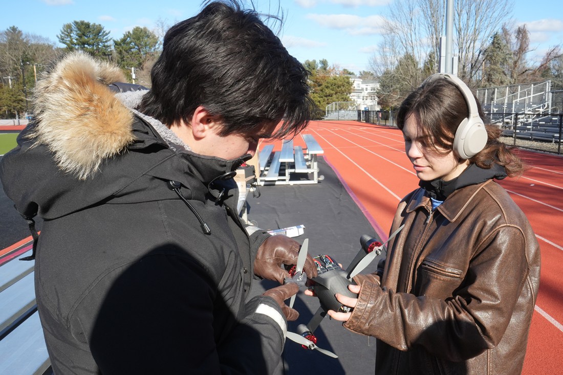 Students adjusting a drone.