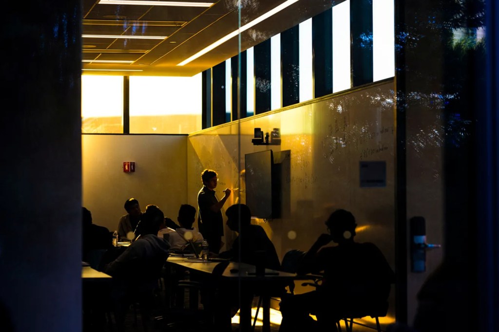 A classroom full of people with the sun shining in the window.