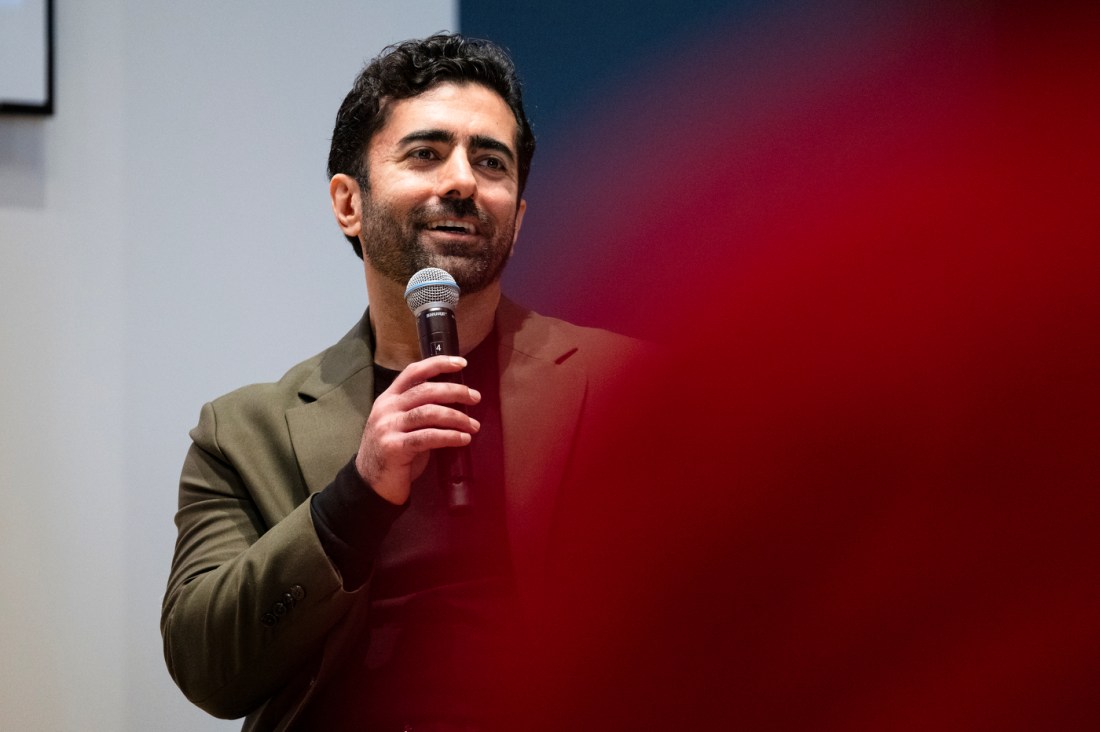 Hamed Tabkhi holding a microphone. 