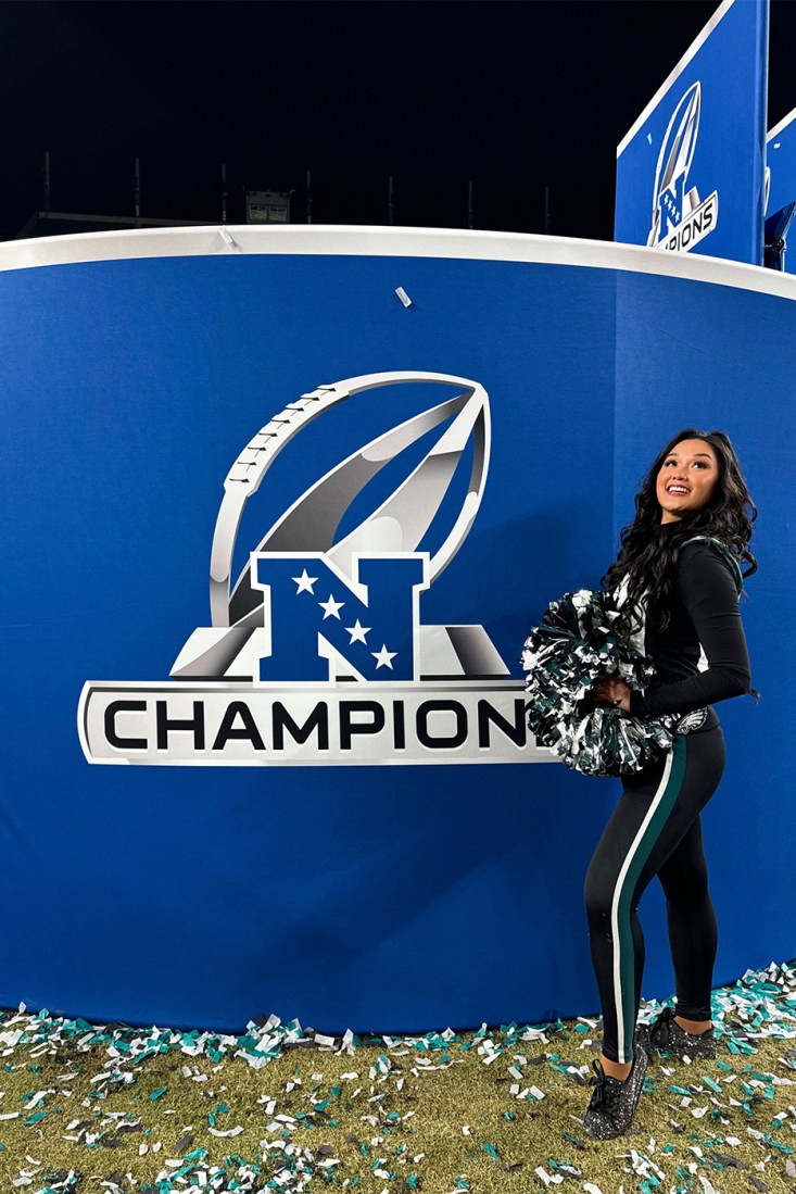 Chelsea Pe Benito holding her pom poms in front of a NFL Champion logo. 