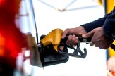 A person using two hands to pump gas into their car. All that&#039;s visible is their hands, not the rest of their body.