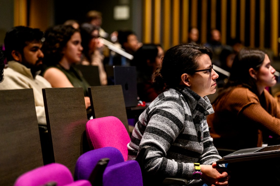 People sitting in an auditorium listening to Herbert Levine speak.