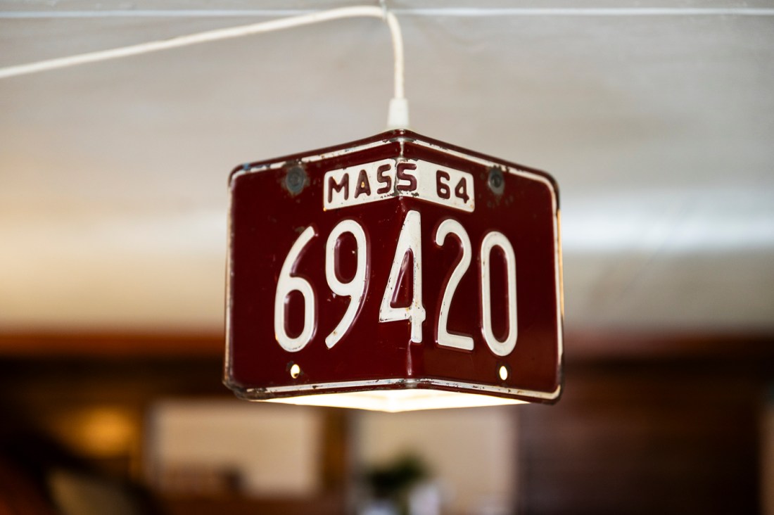 A lampshade made out of Massachusetts license plates bent around a light bulb.