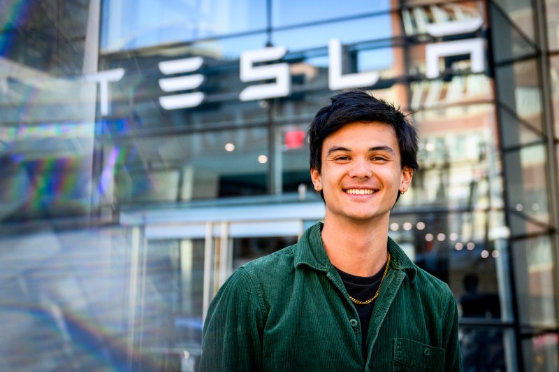 Portrait of Kaden Du standing outside of a Tesla building.