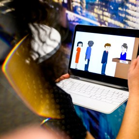 A person playing a video game on a tablet with a keyboard.