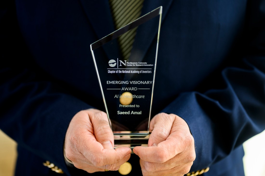 Saeed Amal holding a Emerging Visionary Award.