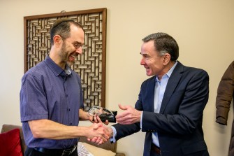David Madigan and Daniel Adlrich shaking hands with each other.