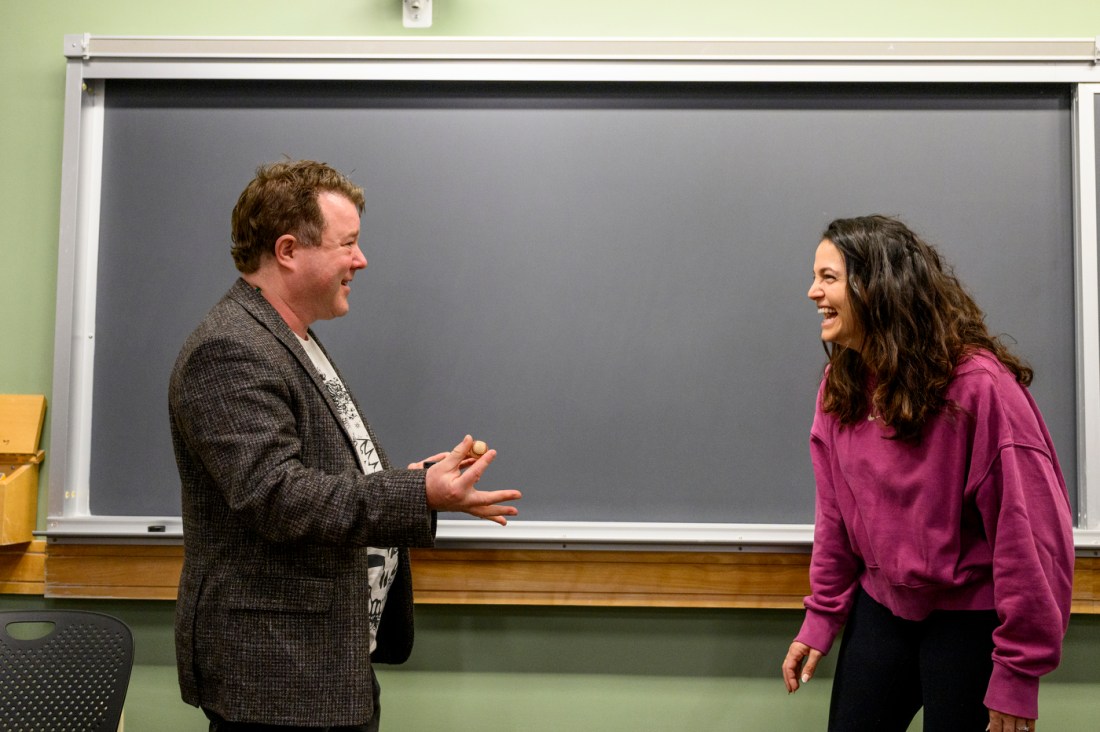 Stephen Wood performing a magic trick to a student.
