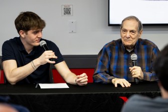 Noah Ben-Zion and Dr. Joseph Berger sitting next to each other holding microphones.