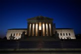 The United States Supreme Court building lit up at night.