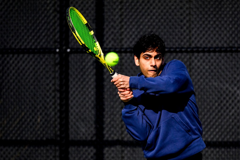 A person hitting a tennis ball with a racquet.