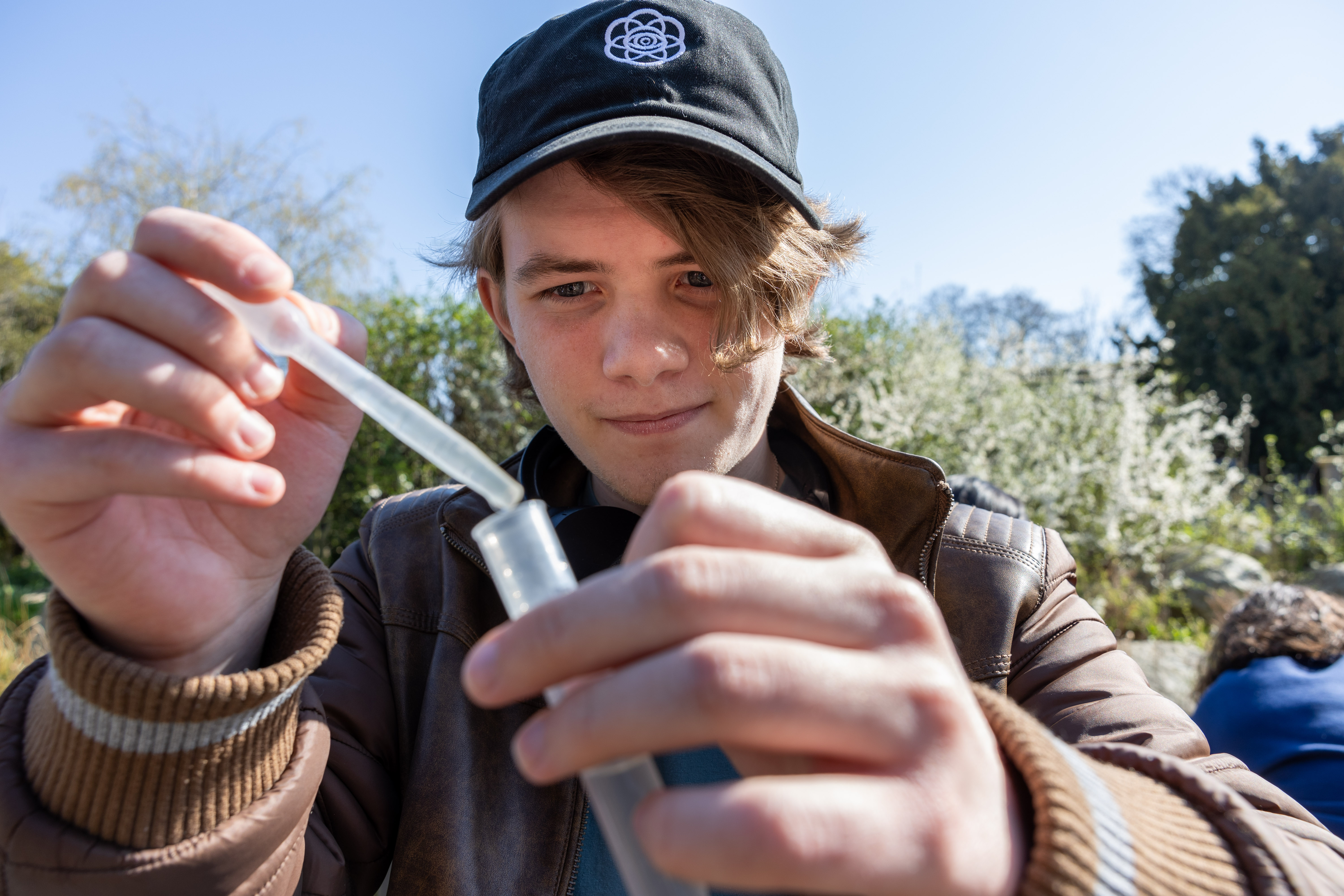 A student holding up an ecological test sample in Hyde Park.