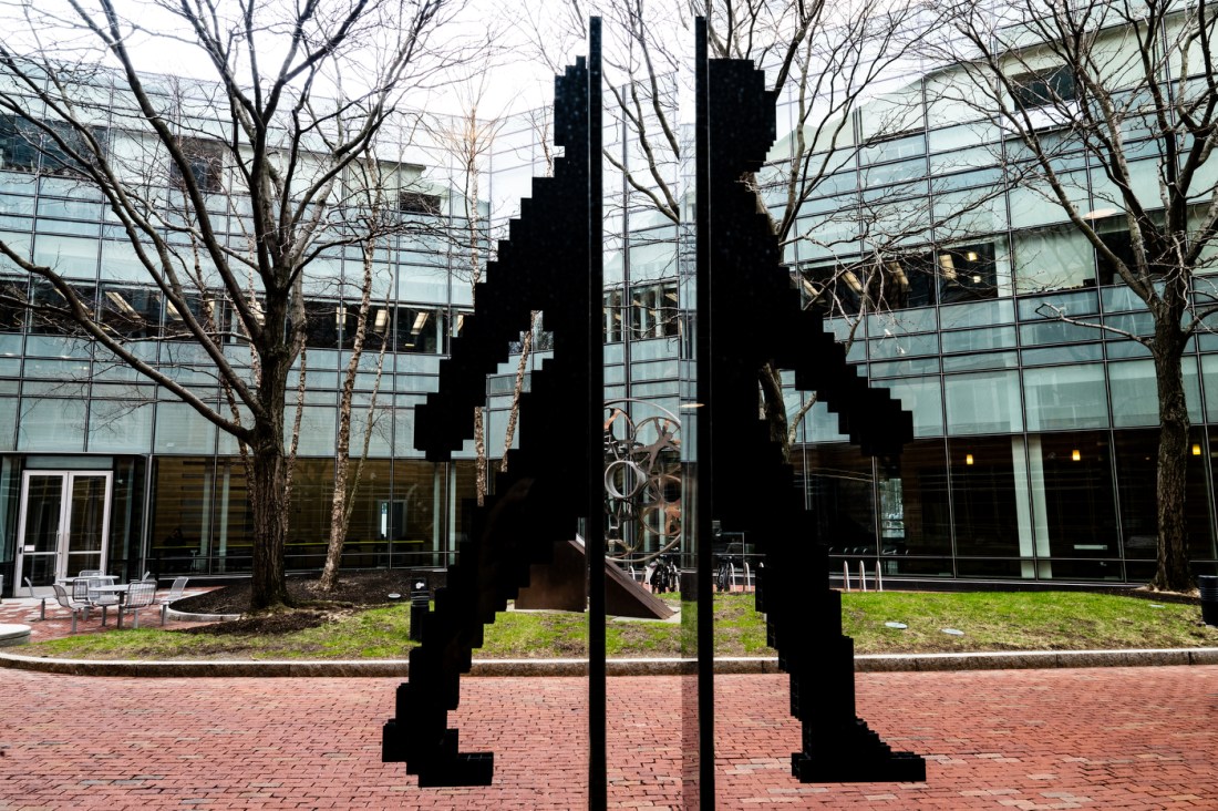A stainless steel sculpture showing a human figure walking but split into two down the middle. 