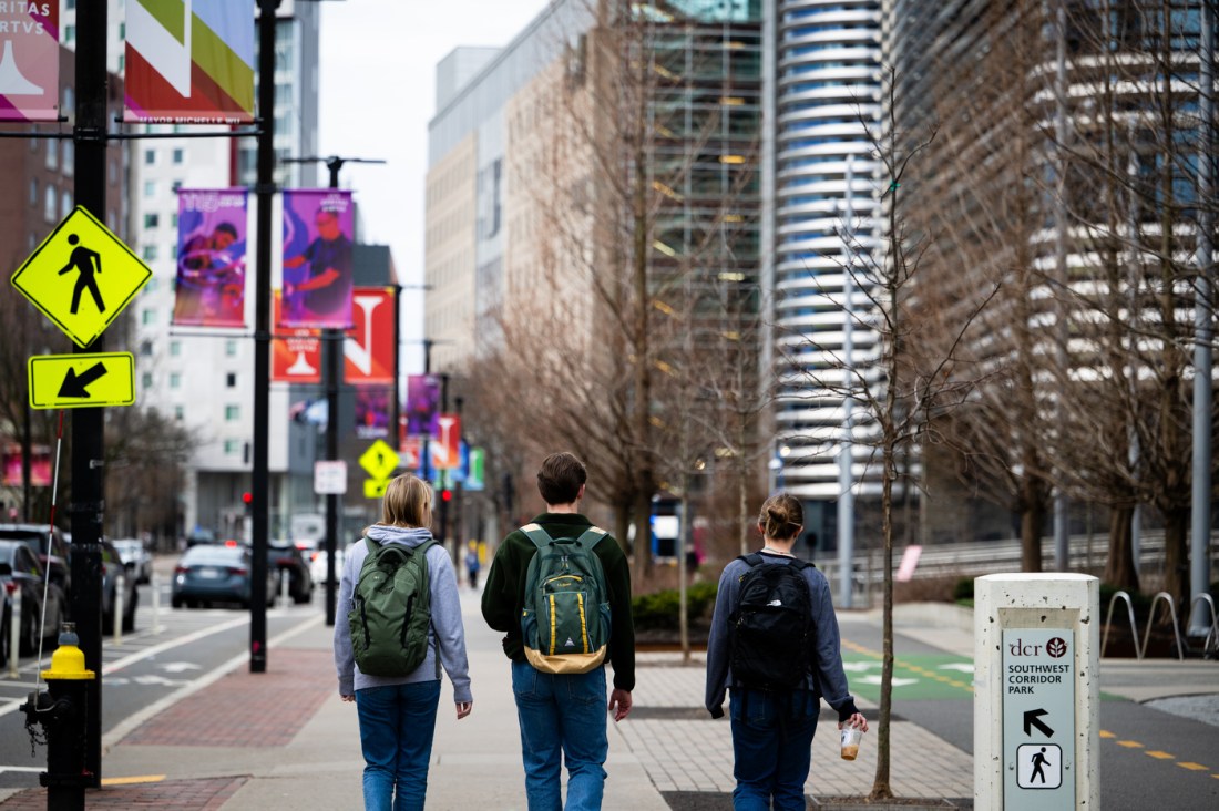 Three members of the Northeastern community walking on campus.