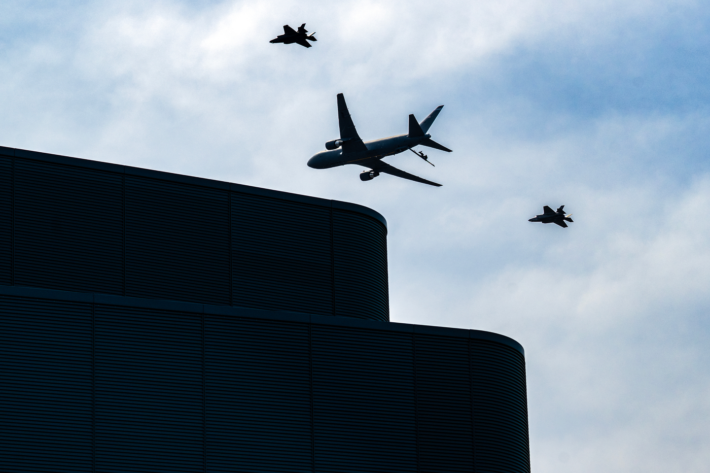 A KC-36 plane flanked by two F-35 jets in the sky.