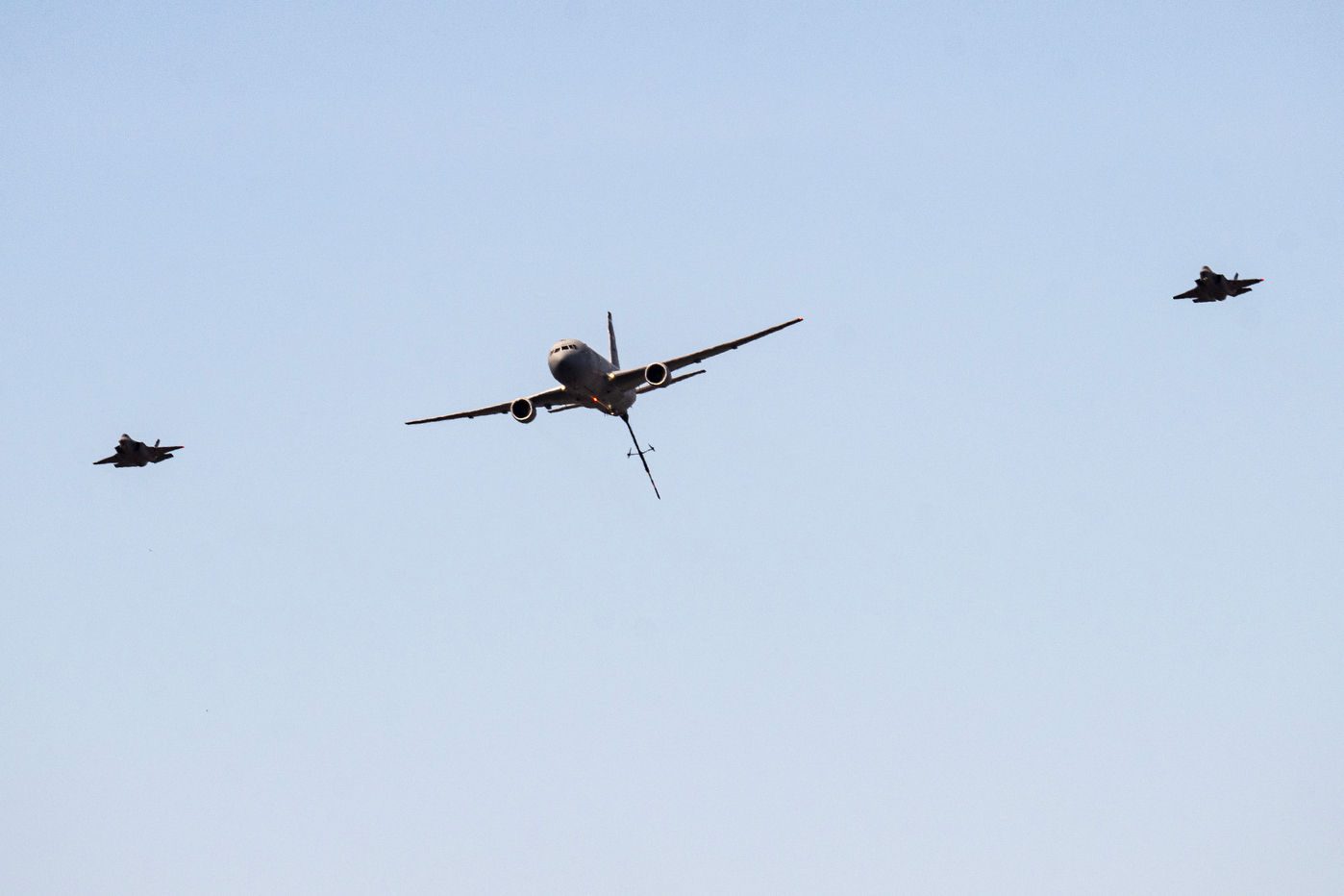 A KC-36 plane flanked by two F-35 jets in the sky.