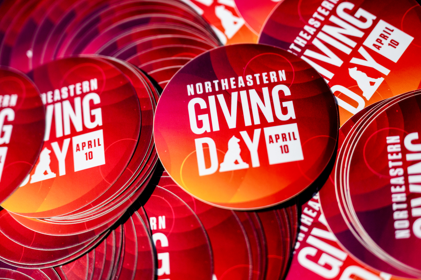 Stacks of Northeastern Giving Day branded stickers. 