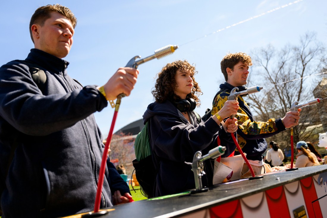 Three people shooting hoses of water at Giving Day 2025.
