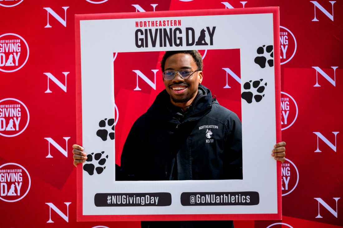 A person posing with a Giving Day frame.