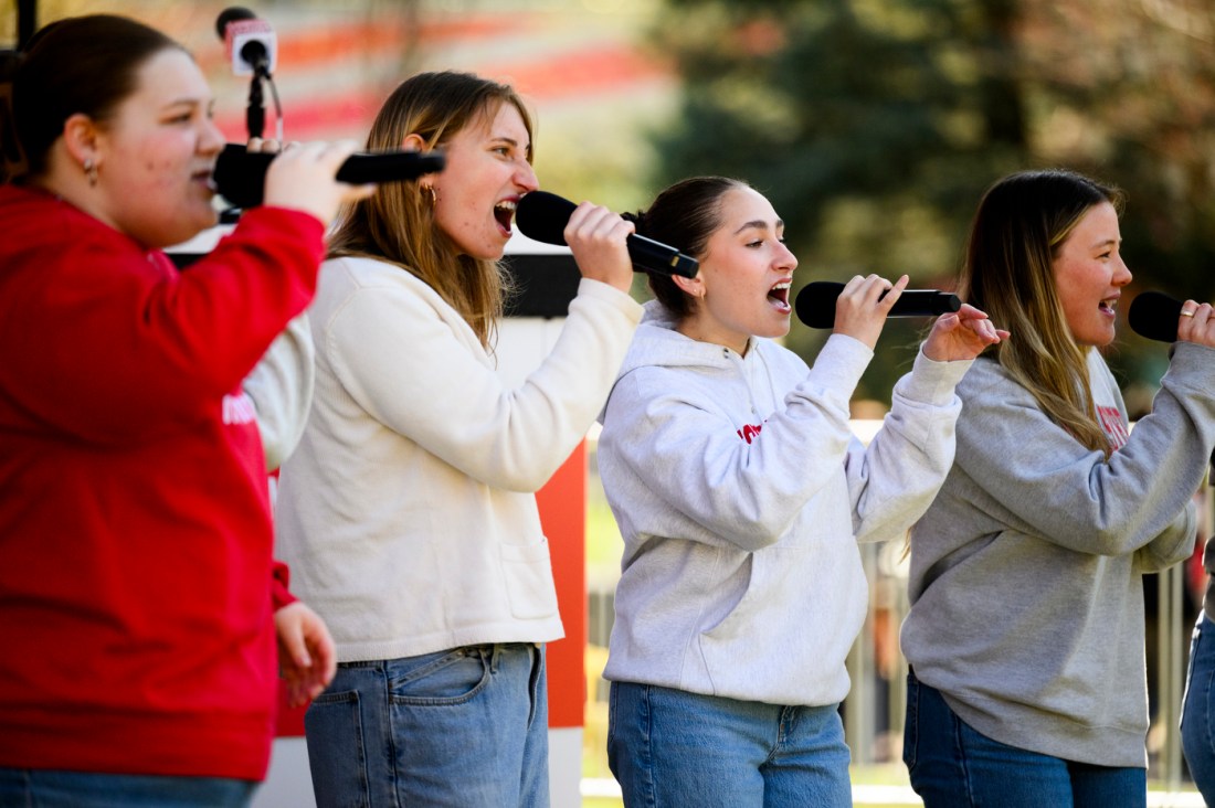 Four people singing into a microphone on stage at Giving Day.