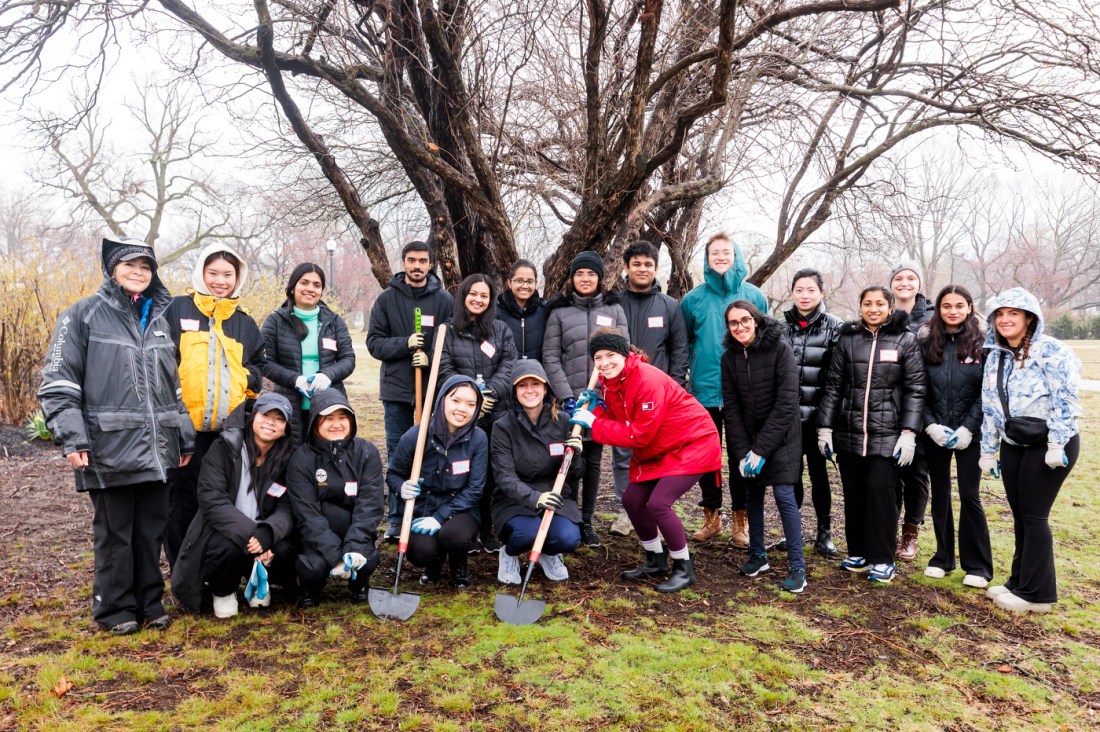 A group of Northeastern community members posing in a park.