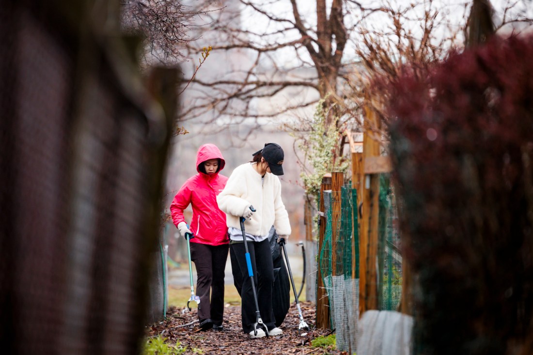 Two Northeastern community members helping clean up a park.