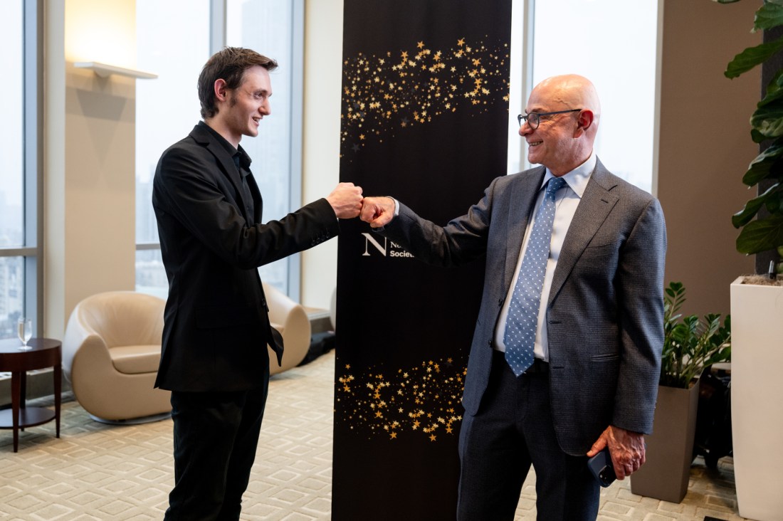 President Aoun bumping fists with a member of the Northeastern community at the Huntington 100 Induction Ceremony.