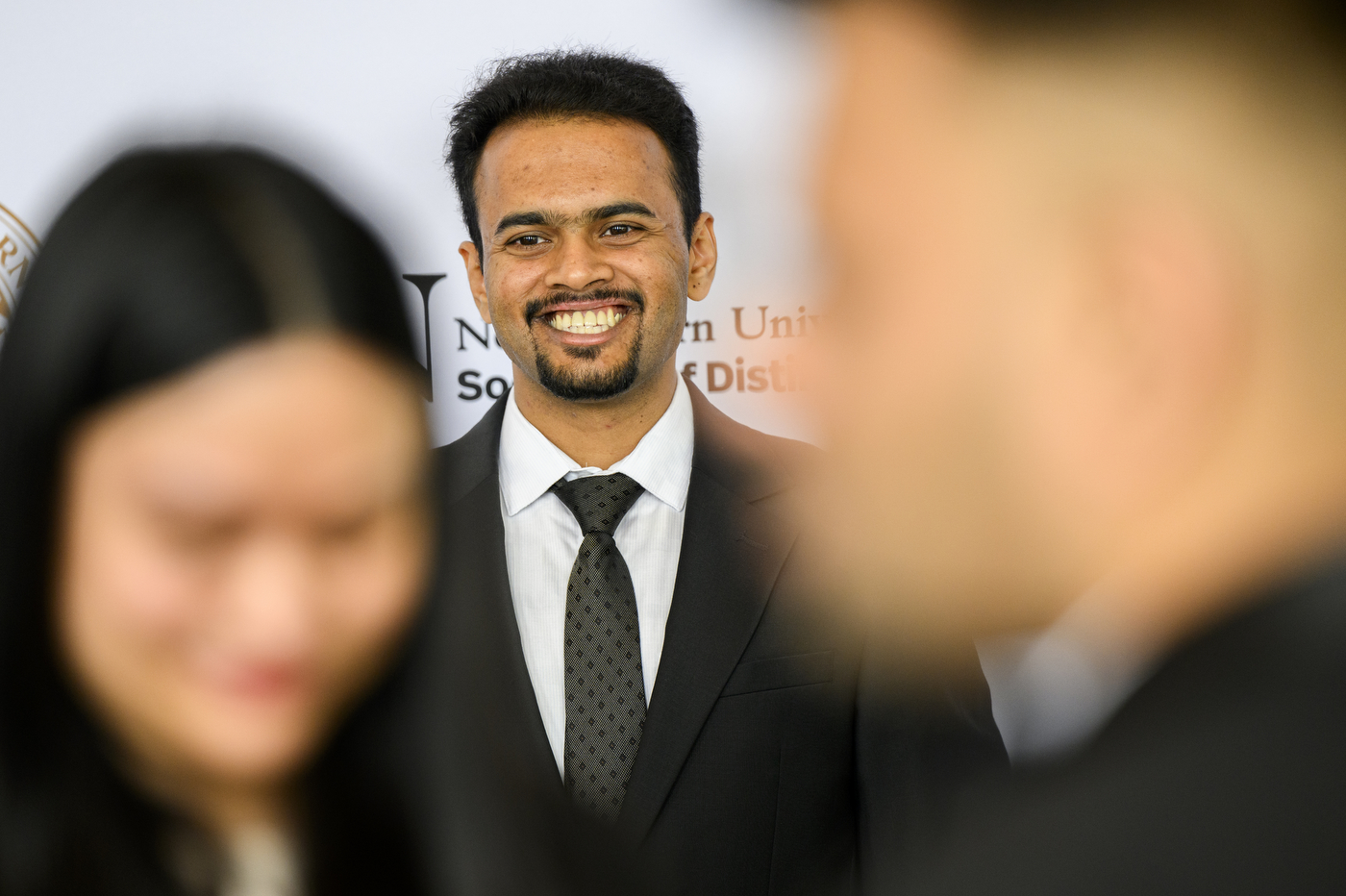 A student smiling for a photo at the Laurel & Scroll Induction Ceremony.