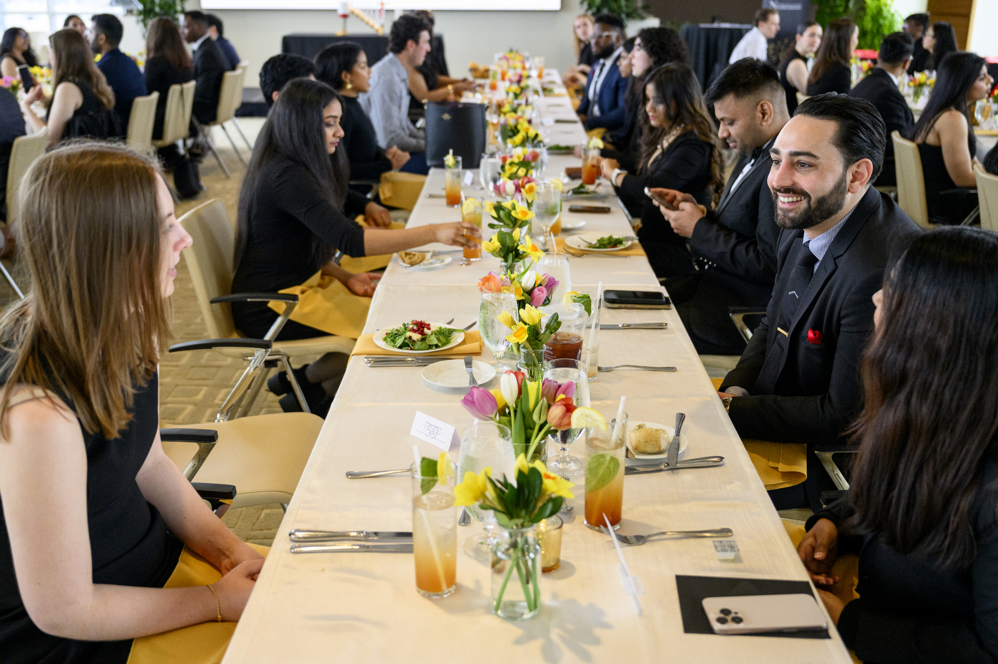 Students sitting at a long table for a meal at the Laurel & Scroll Induction Ceremony.