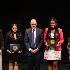 Students stand on either side of Northeastern's President Aoun at the Academic Honors Convocation.