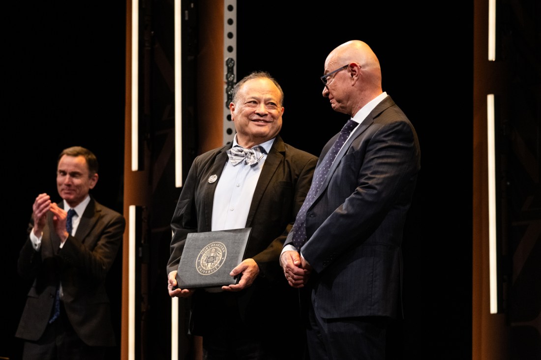 President Aoun standing next to a Northeastern faculty members receiving an honors.
