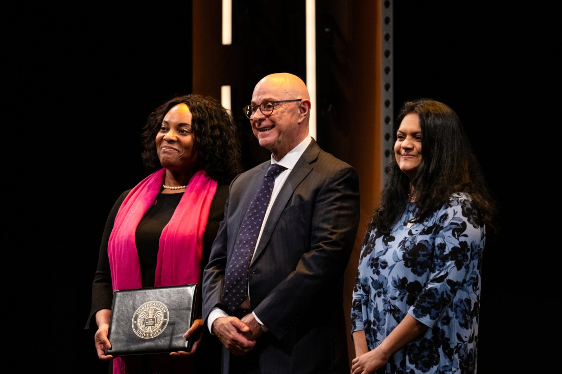 President Aoun standing next to two Northeastern faculty members receiving an honors.