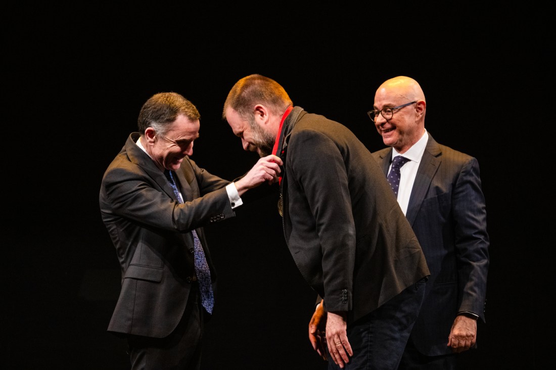 David Madigan placing a medal around another faculty member's neck. 