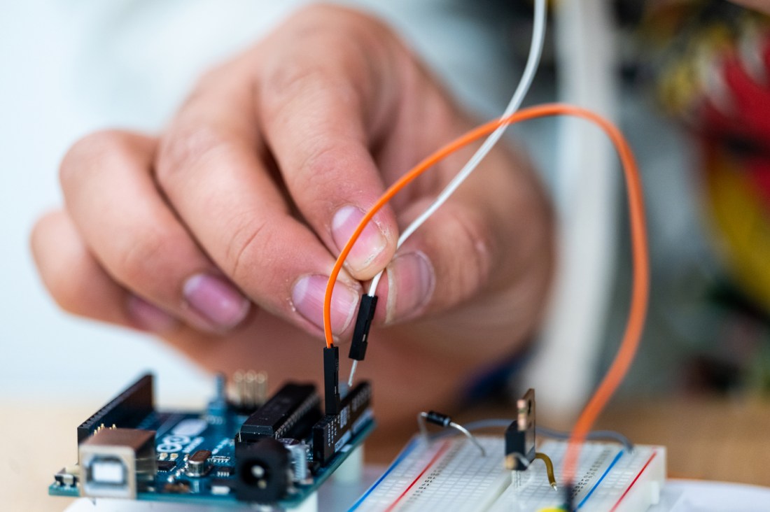 A hand holding several wires at the EPX makerspace.