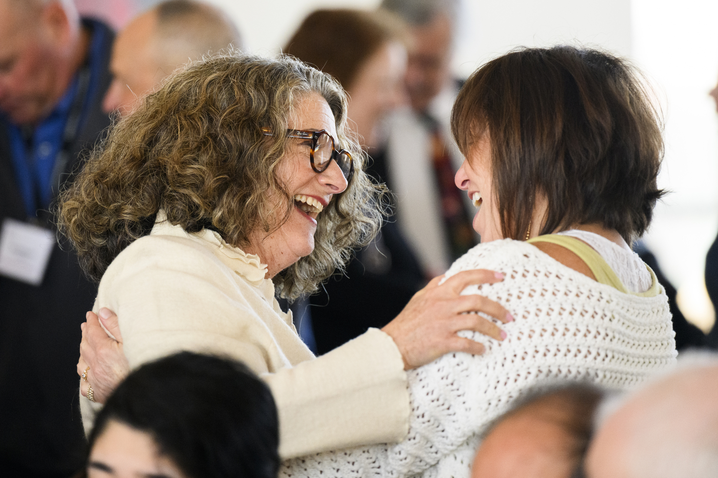 Two people greeting each other at the 25 Year Associates Brunch.