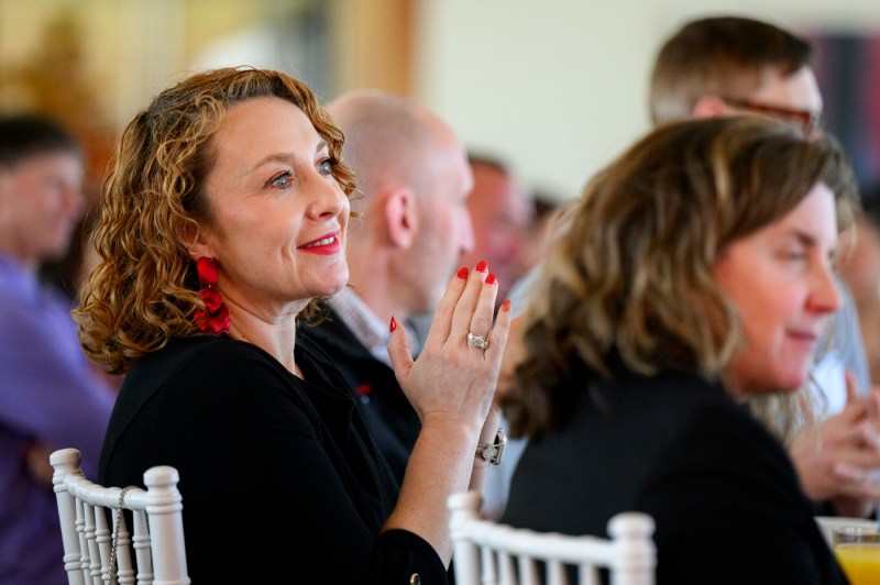 A member of the Northeastern community clapping at the 25 year associates brunch.